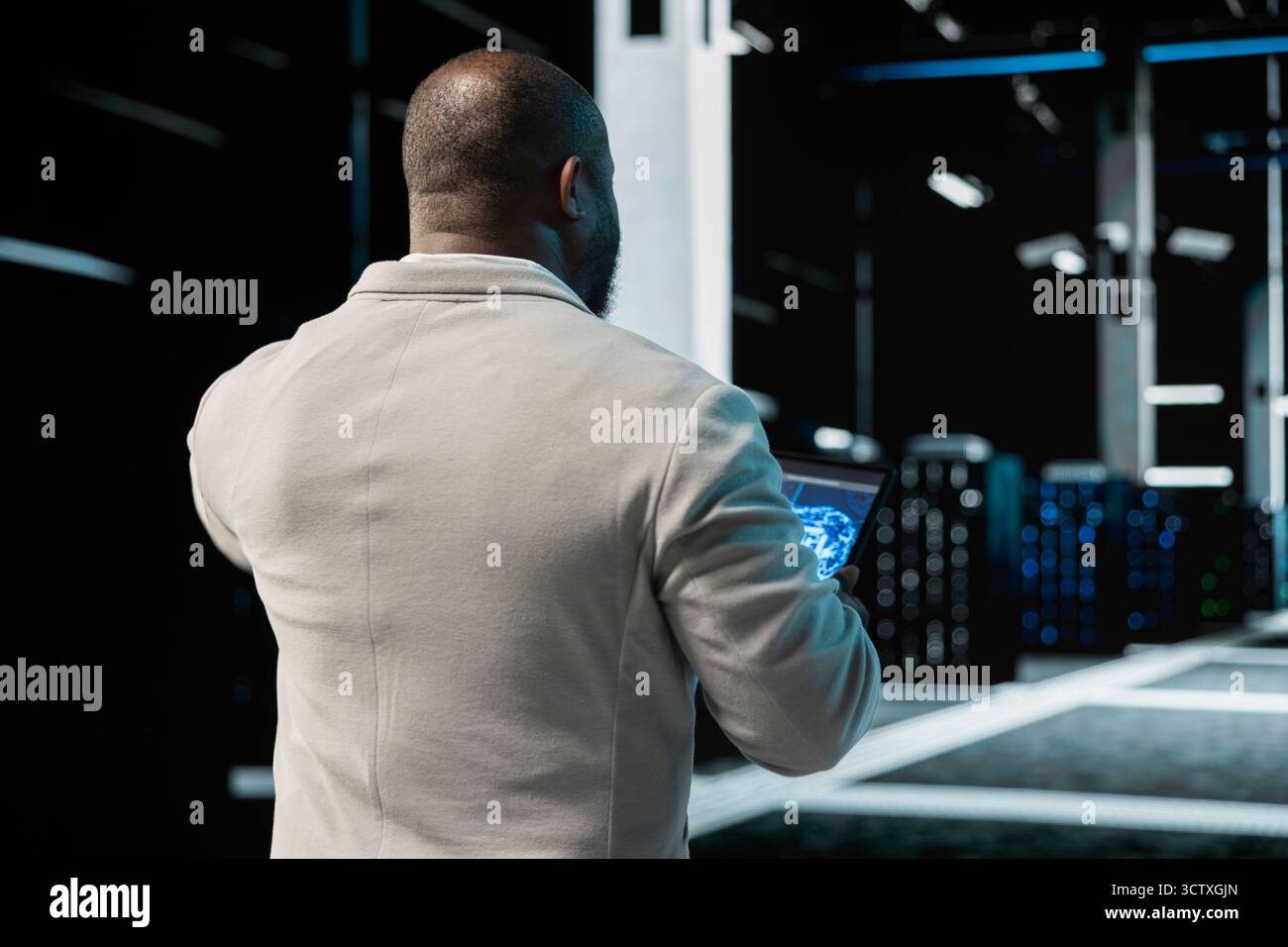 Data center engineer using AI technology on tablet to enhance operational effectiveness. Server hub worker utilizing artificial intelligence technology to predict future infrastructure needs Stock Photo