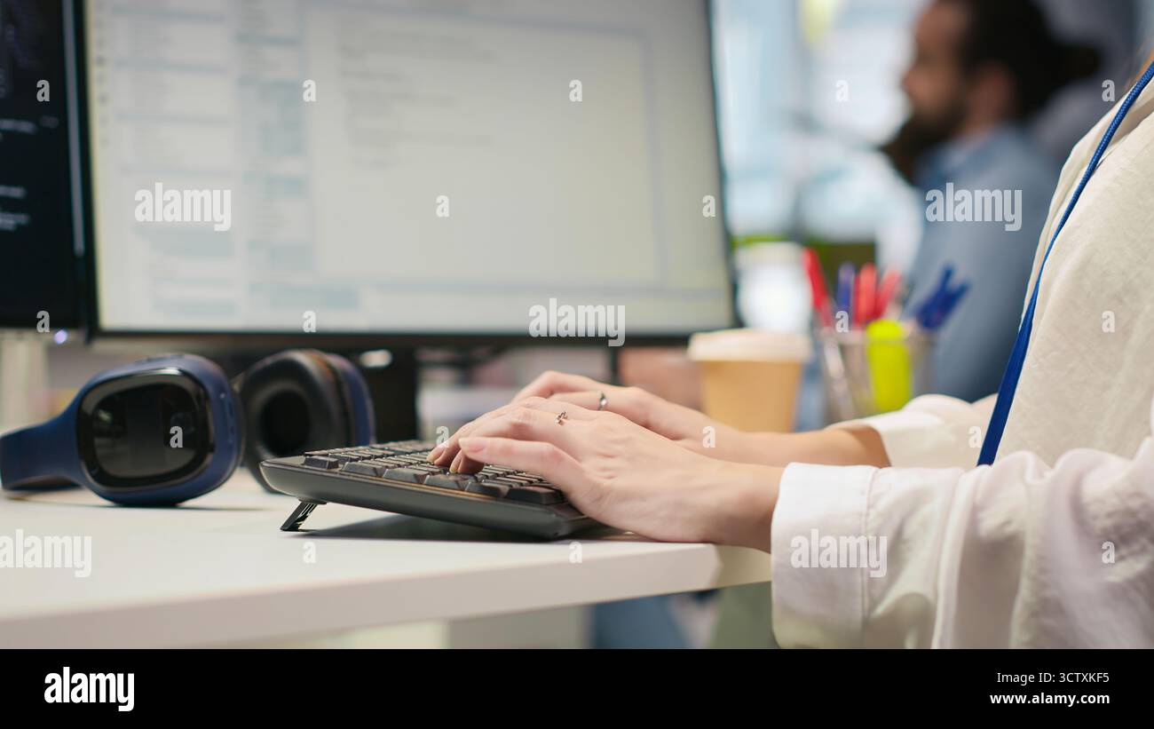 Startup office IT professional using AI LLM chatbot, optimizing systems performance. Computer scientist uses artificial intelligence assistant to automate workflows, camera A Stock Photo