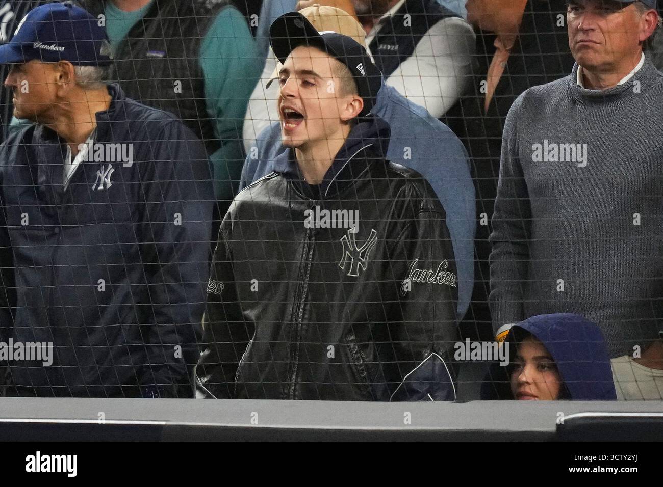 Timothee Chalamet, center, reacts while watching Game 4 of baseball's ...