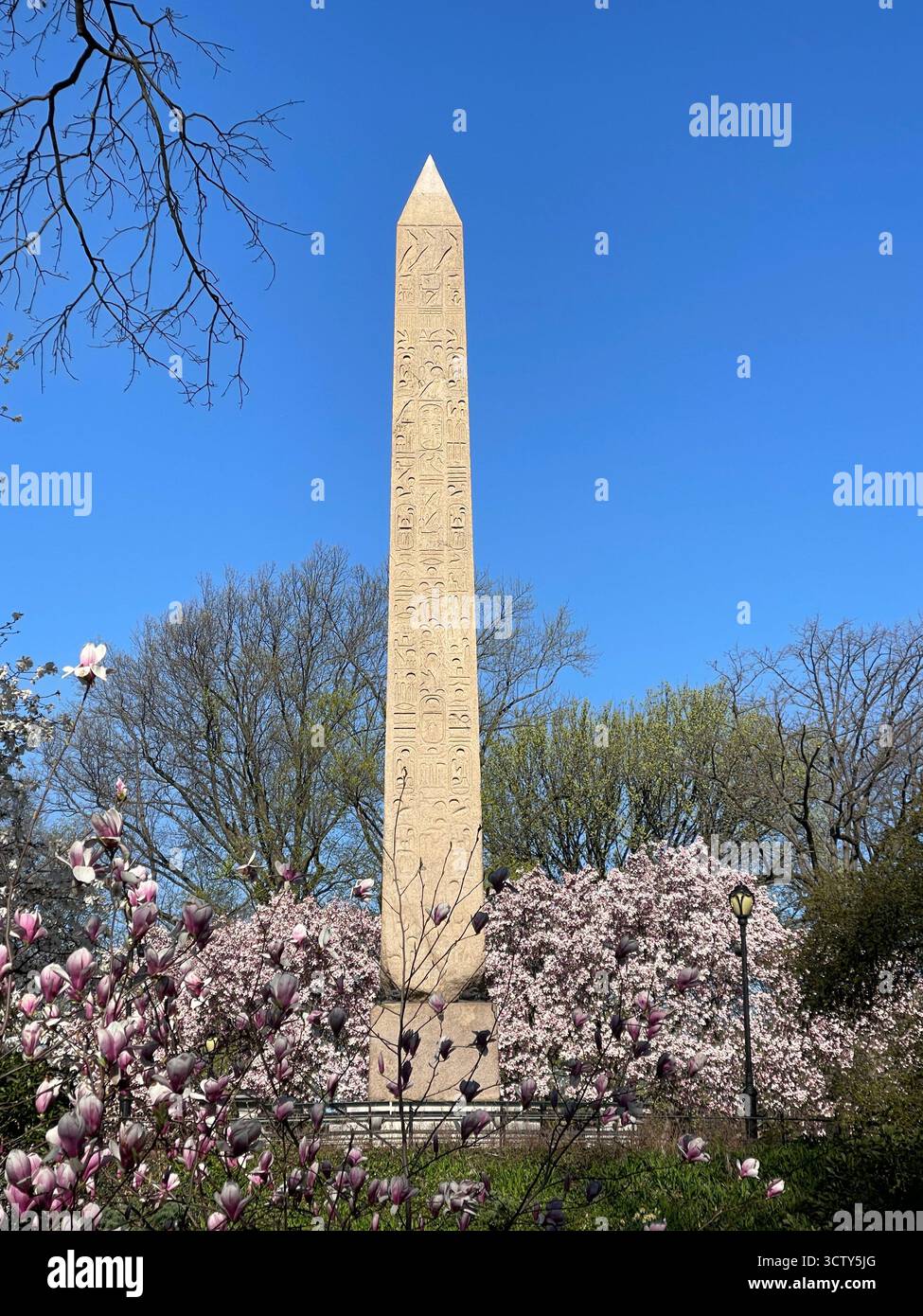 The Obelisk, also known as Cleopatra’s Needle, in Central Park, New York City — standing tall amidst the park’s spring flowers - Smartphone Captured Stock Image