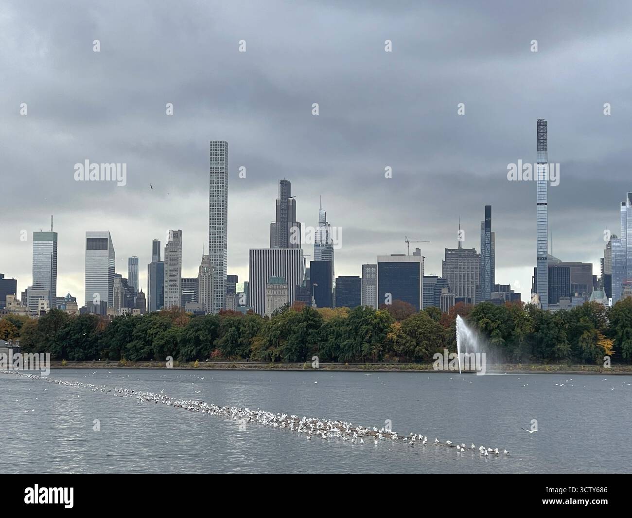The Jacqueline Kennedy Onassis Reservoir in Central Park, New York City, under a dramatic stormy sky — dark clouds reflecting on the restless waters. - Smartphone Captured Stock Image