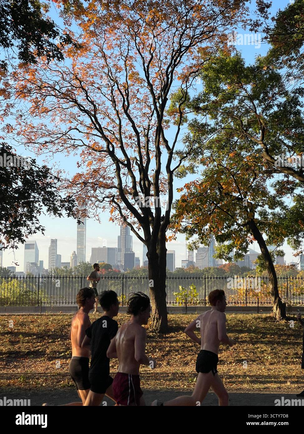 Early morning at the Jacqueline Kennedy Onassis Reservoir in Central Park, New York City, as runners pass by — a bustling start to a crisp fall day. - Smartphone Captured Stock Image