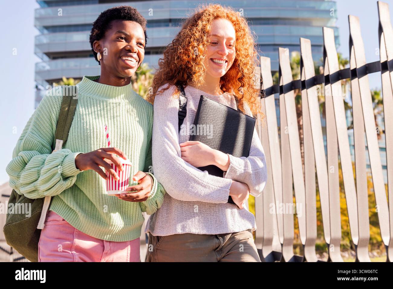 two young students walking down street Stock Photo
