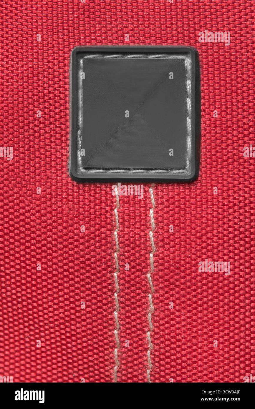 Blank rubber patch stitched on red waterproof fabric background Stock Photo