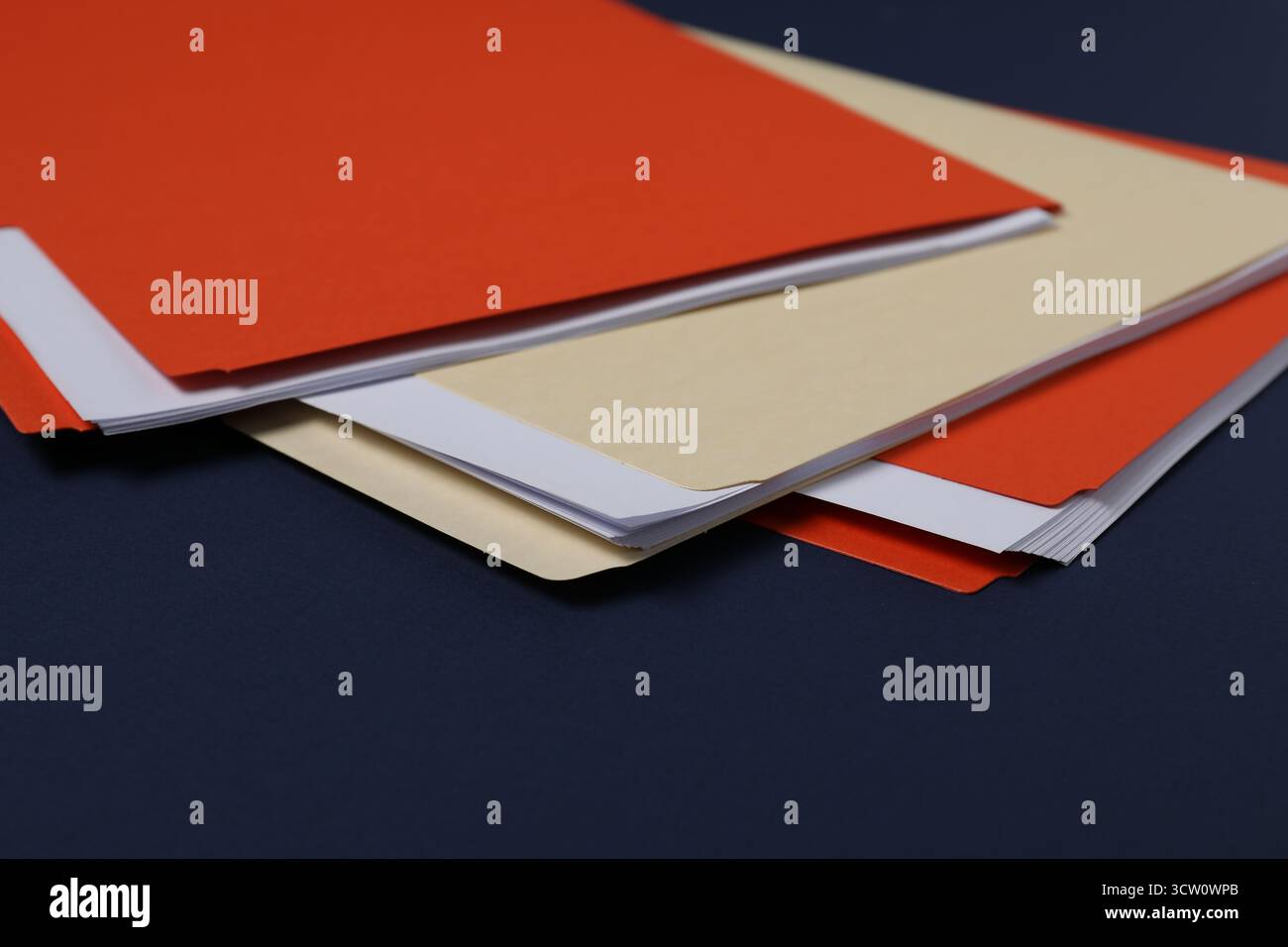 Many documents in folders on dark blue background, closeup Stock Photo