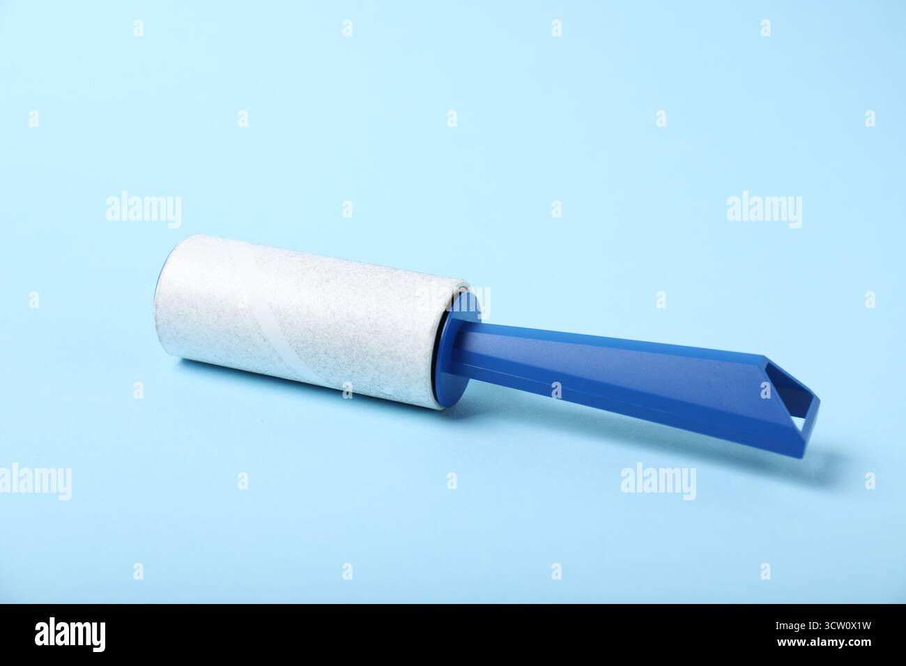 One lint roller on light blue background, closeup Stock Photo
