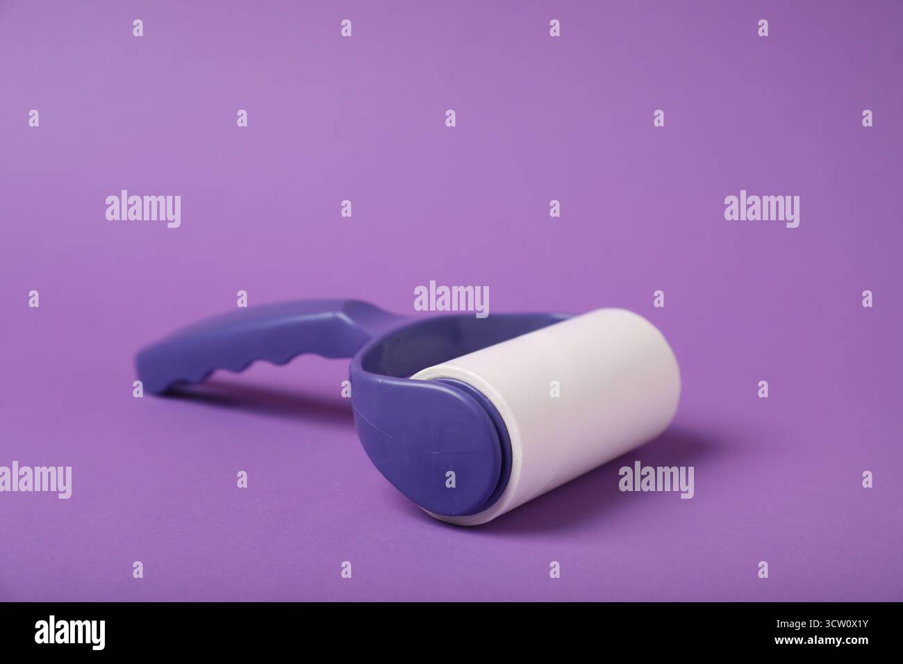 One lint roller on purple background, closeup Stock Photo