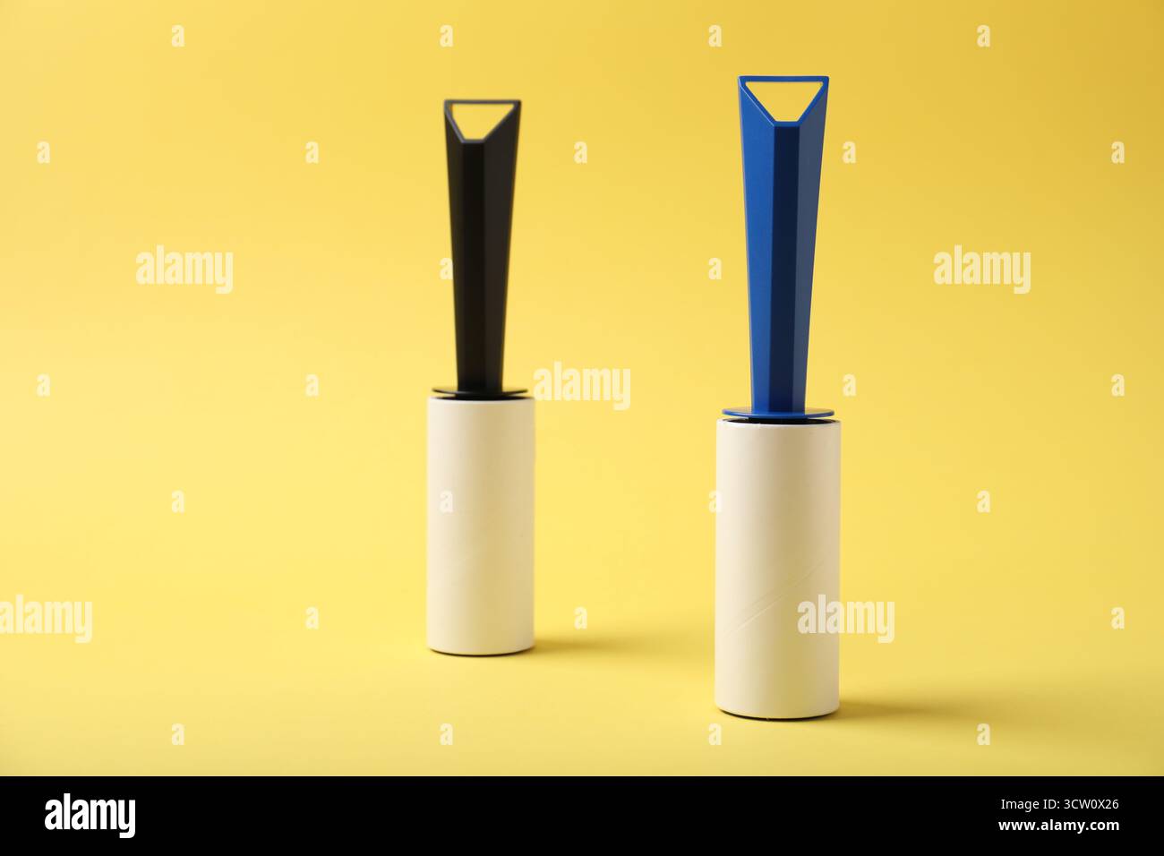 Two sticky lint rollers on yellow background Stock Photo