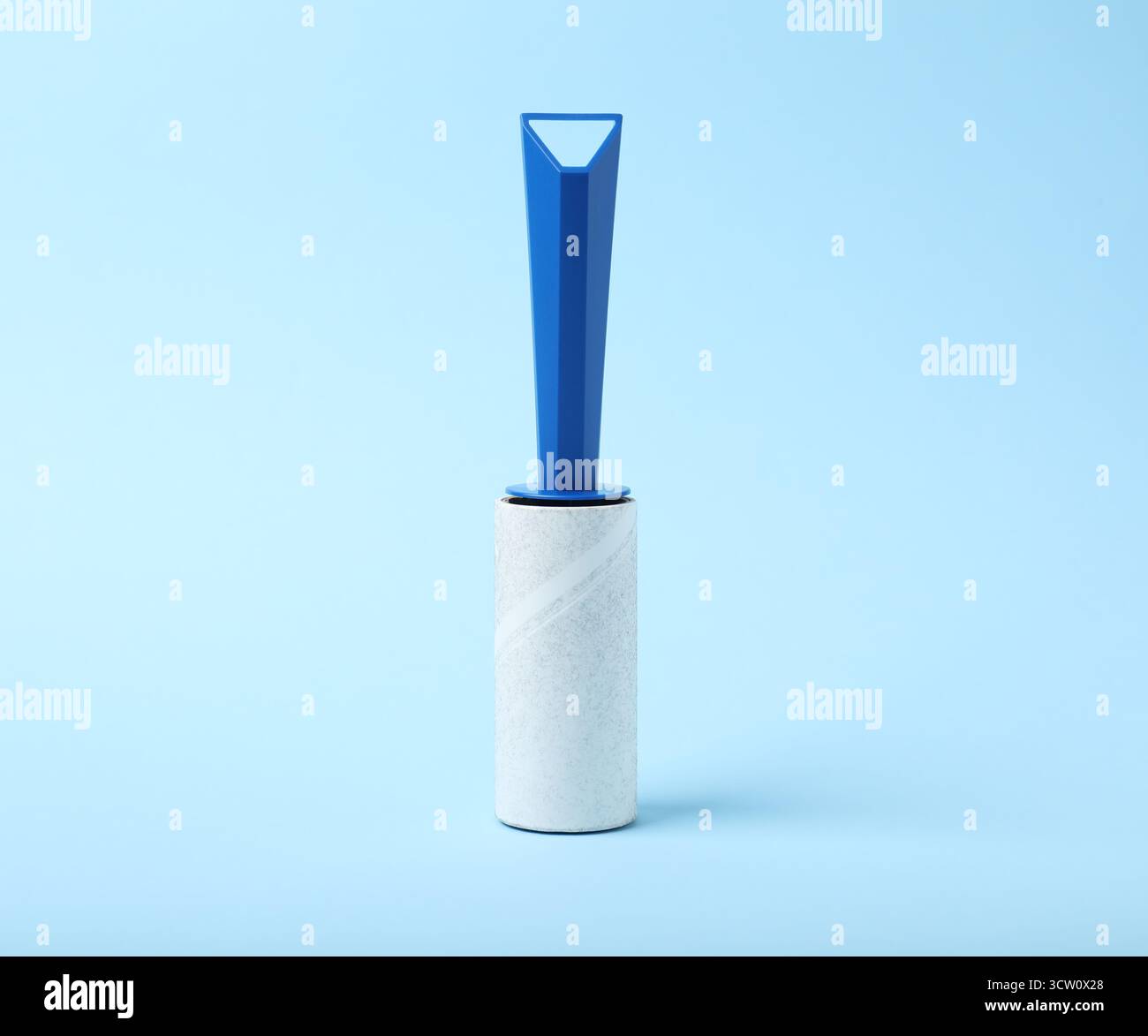 One lint roller on light blue background Stock Photo