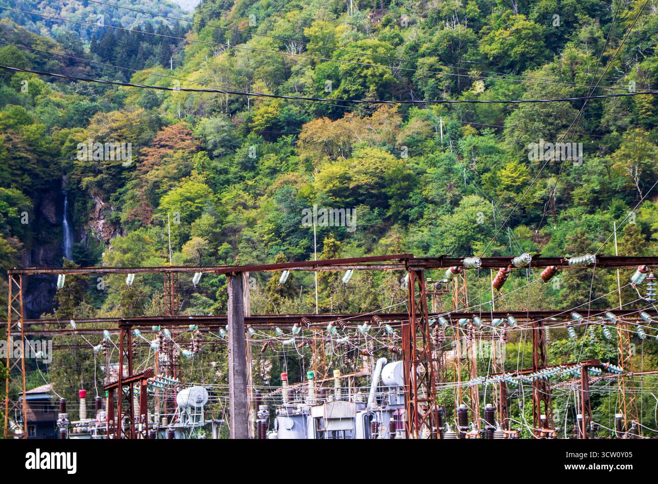 High voltage power lines with forest on the background Stock Photo - Alamy