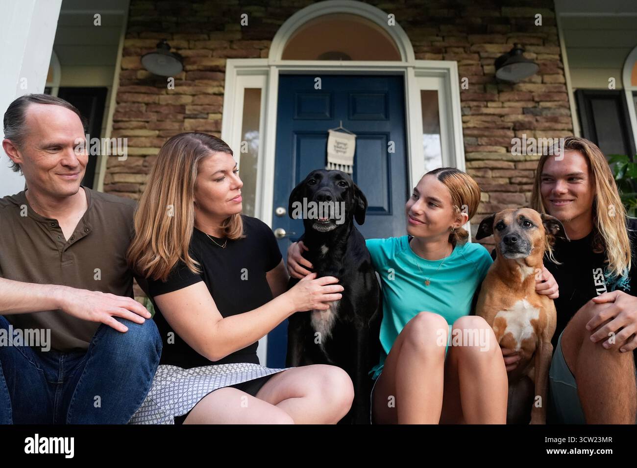 Meaghan and Chris Marr pose with their children and dogs for a ...