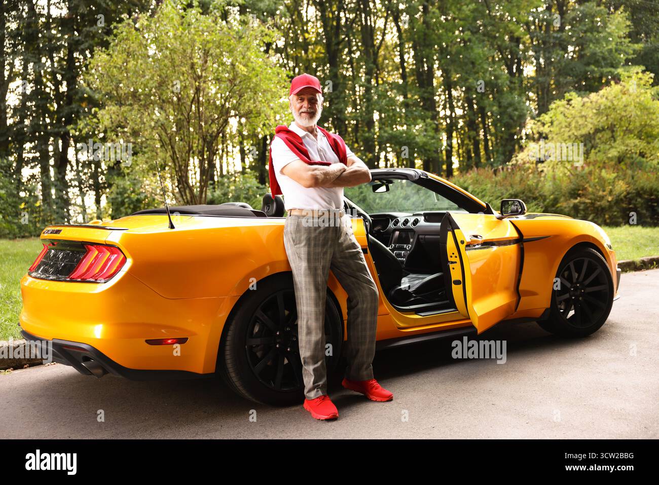 Stylish senior man getting out of modern cabriolet outdoors Stock Photo