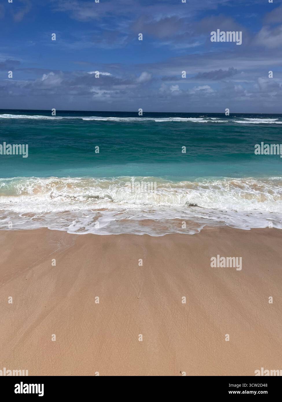 Tranquil seascape with soft sand, calm sea, and a clear blue sky. A peaceful coastal scene capturing the beauty of nature and open space. - Smartphone Captured Stock Image