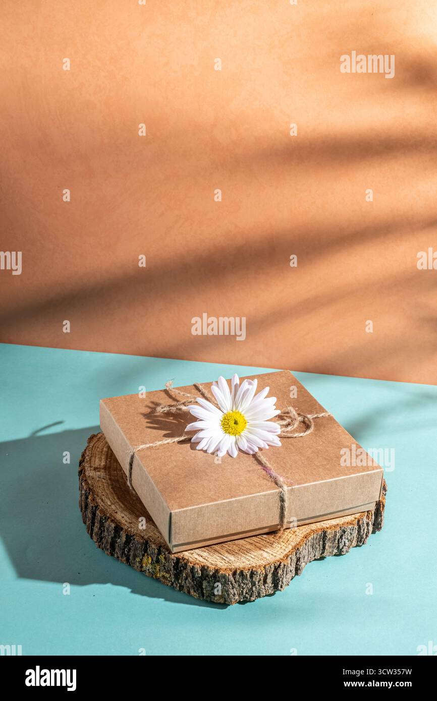 Craft gift box decorated with chamomile flower. Stock Photo