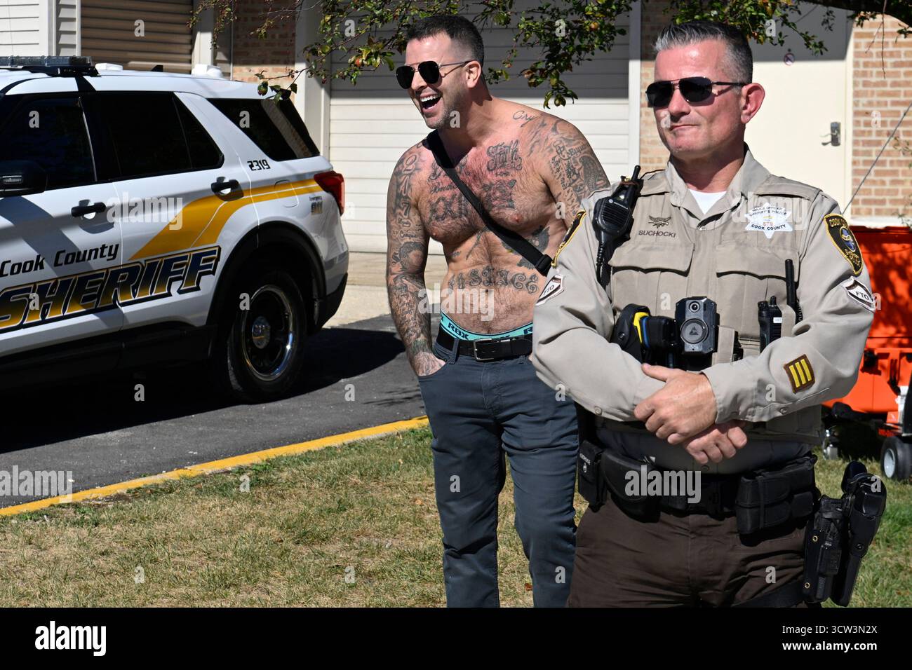 A counter protestor yells behind a Cook County Sheriff at demonstrators ...