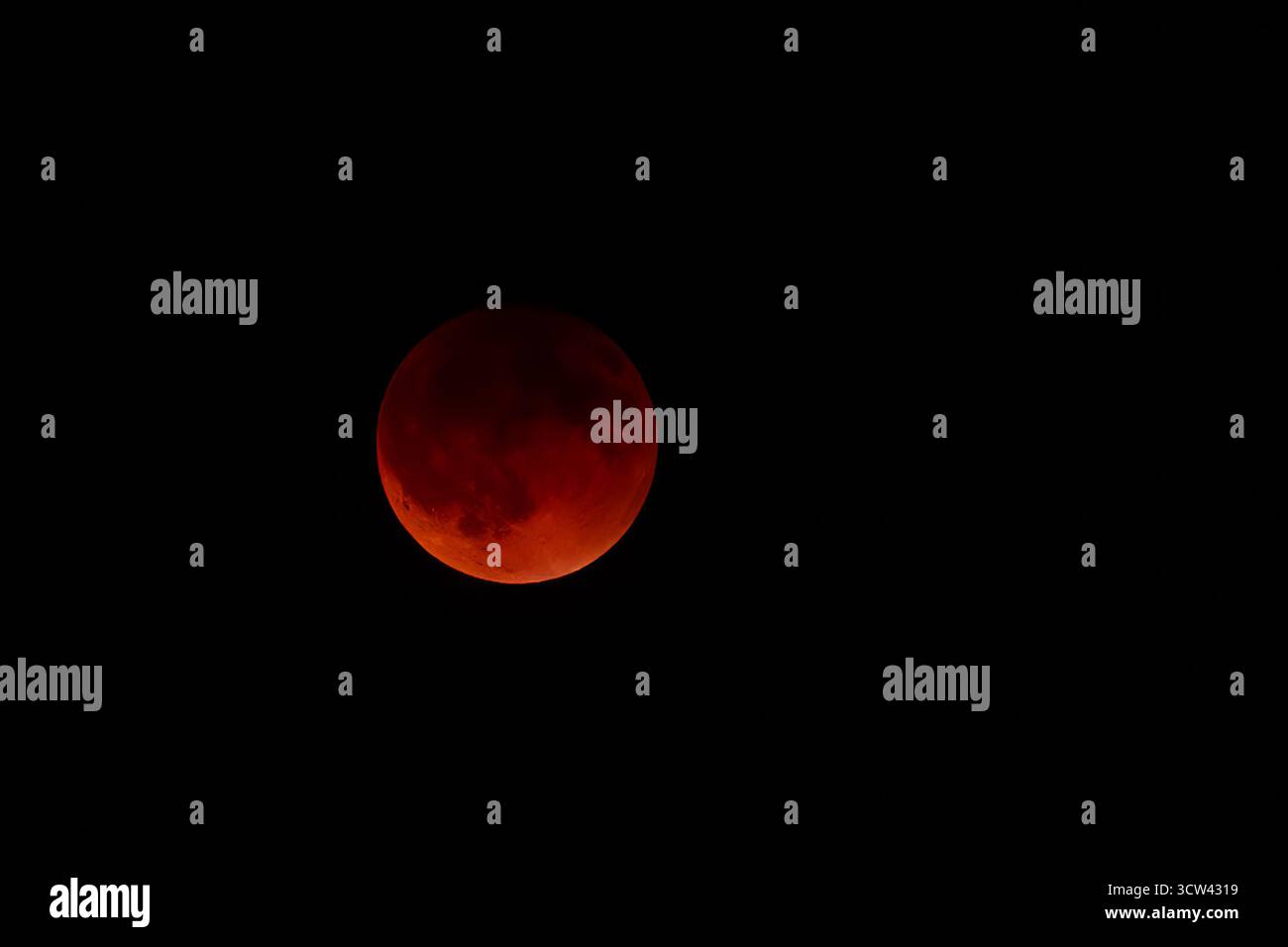 The full Moon appears deep red during a total lunar eclipse, standing ...