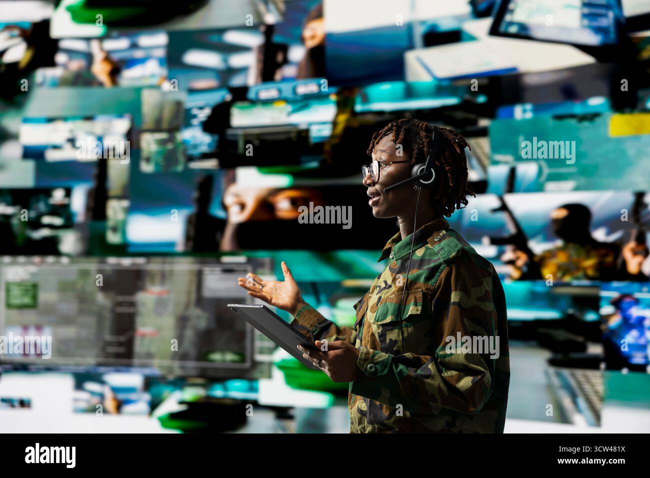 Army dispatcher wearing audio headset working in command center housing ...