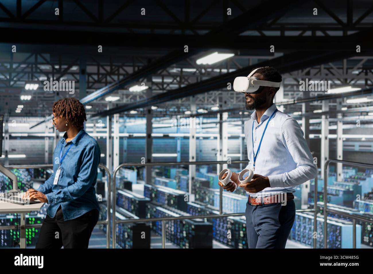 Black engineer using VR headset in data center to update server tech, configuring equipment using software tools. Server hub employee reviewing hardware analytics using virtual reality. Stock Photo