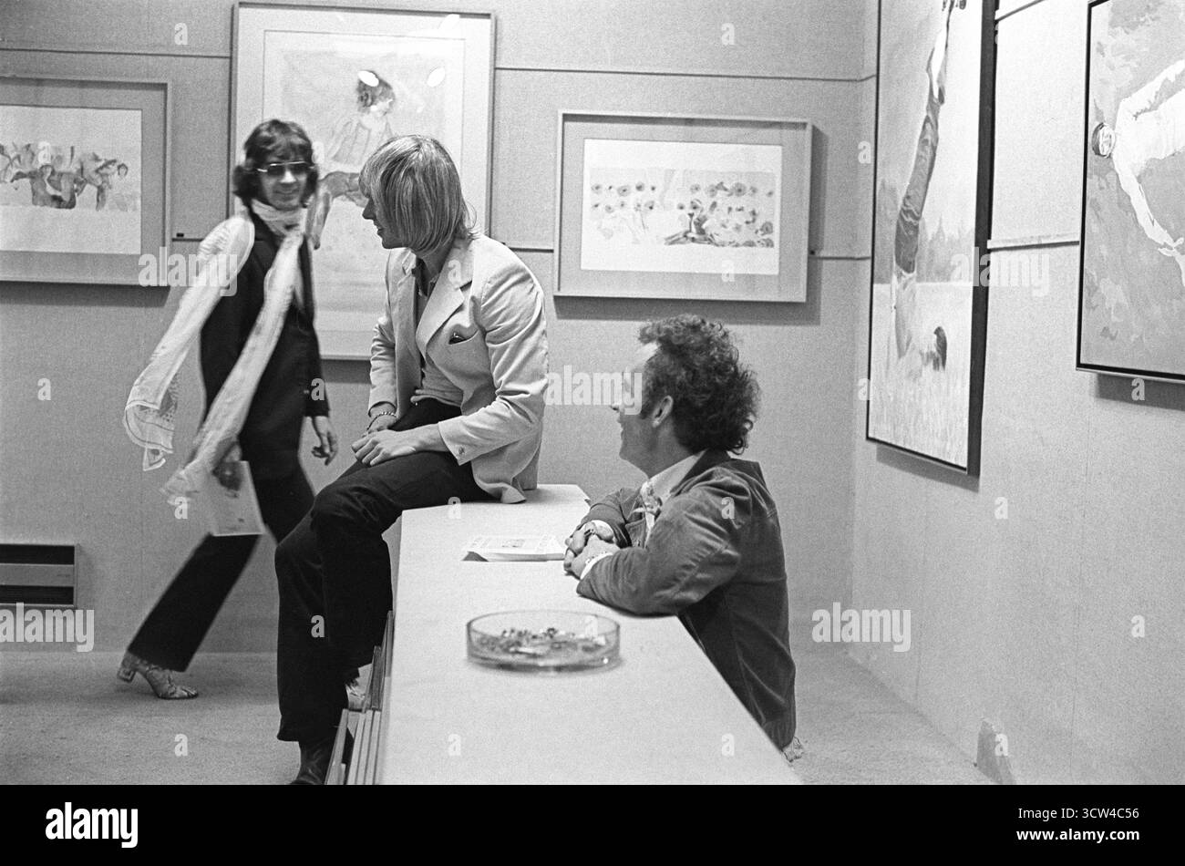 London, England 22nd April 1969. Patrick Procktor's opening night private view of his show at the Redfern Gallery, Cork Street London. Ossie Clark, Peter Hinwood, Patrick Proctor. The painting on the wall behind of the man with his feet in the air is a portrait of Gervase Griffiths muse of Patrick Procktor 1960s UK HOMER SYKES Stock Photo