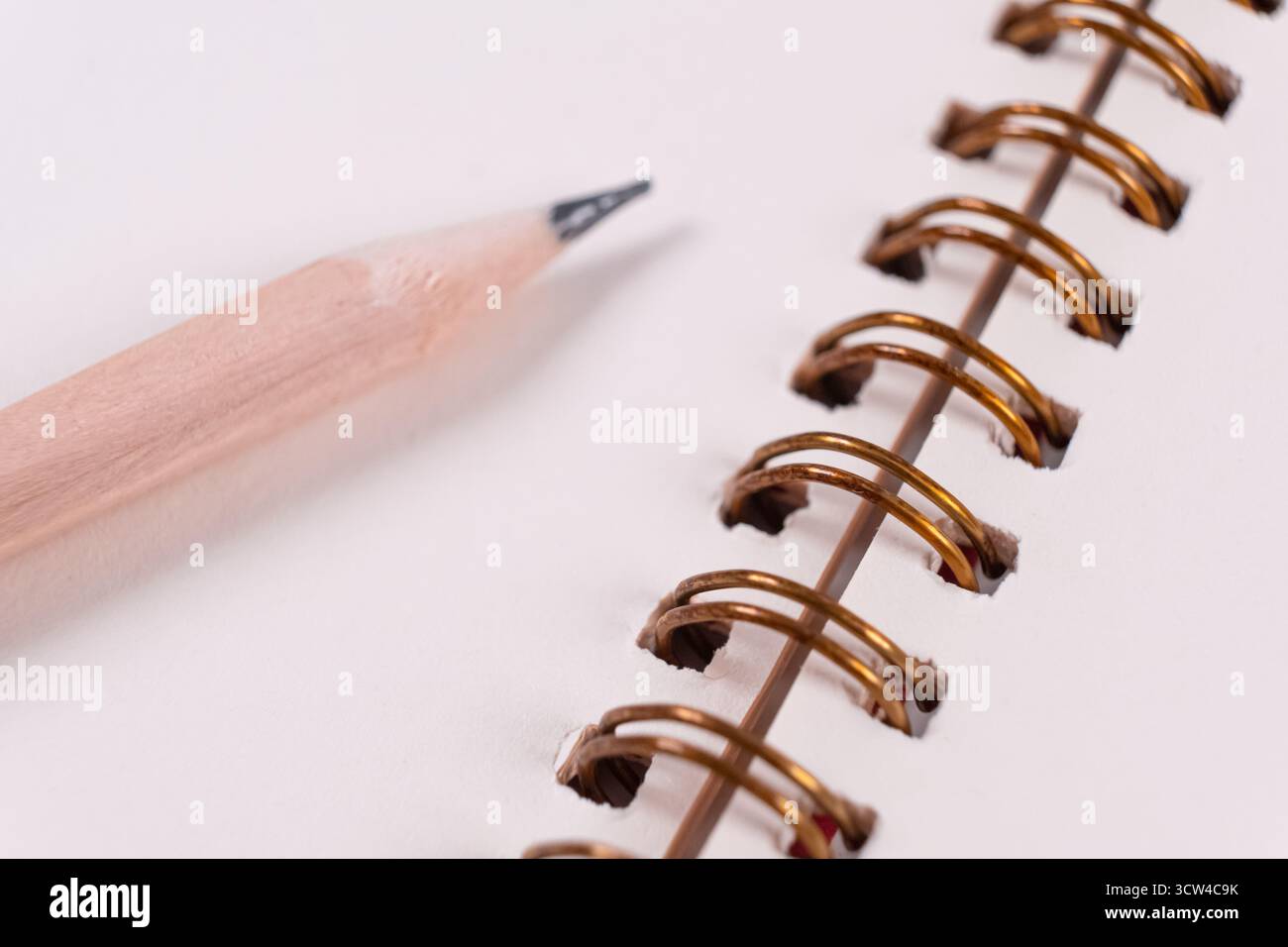Spiral notebook and pen. Close-up of blank paper notebook in a binder with metal ring binding, macro Stock Photo