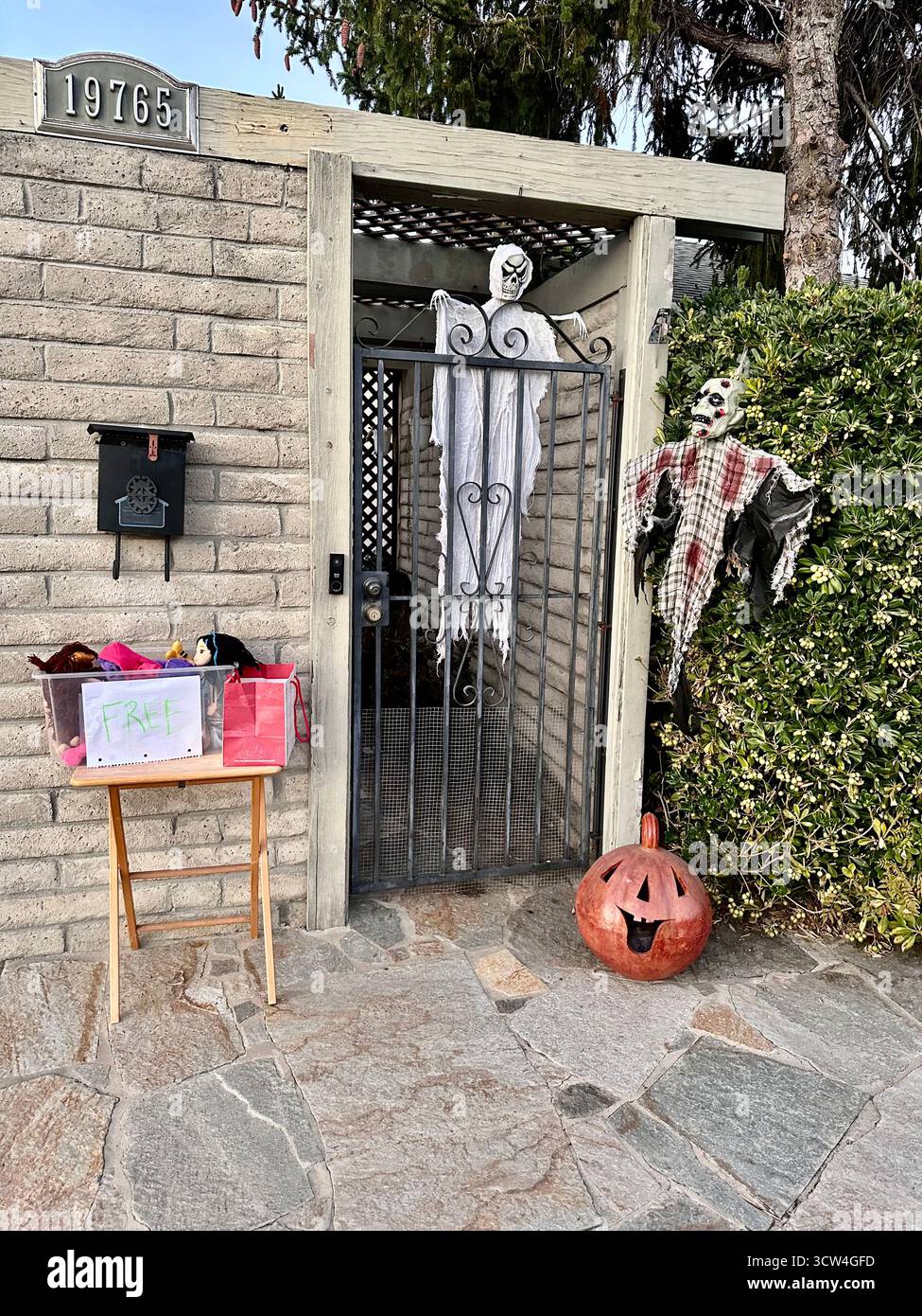 Halloween Ghosts and Pumpkin Decorations by a Gated Entrance - Smartphone Captured Stock Image