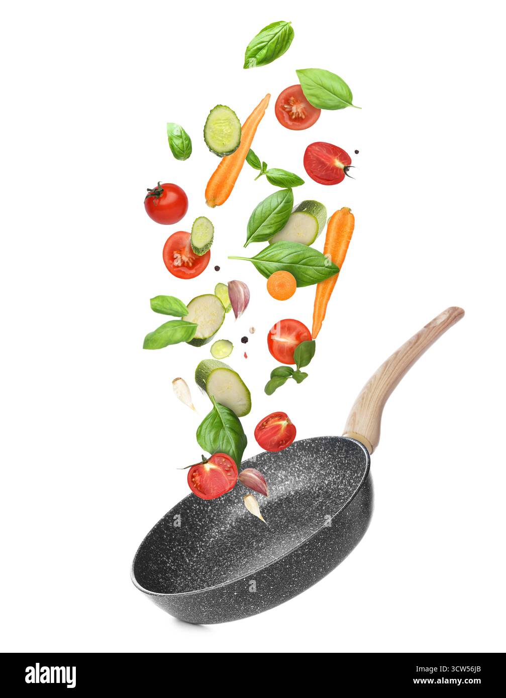 Frying pan and different flying vegetables on white background Stock Photo