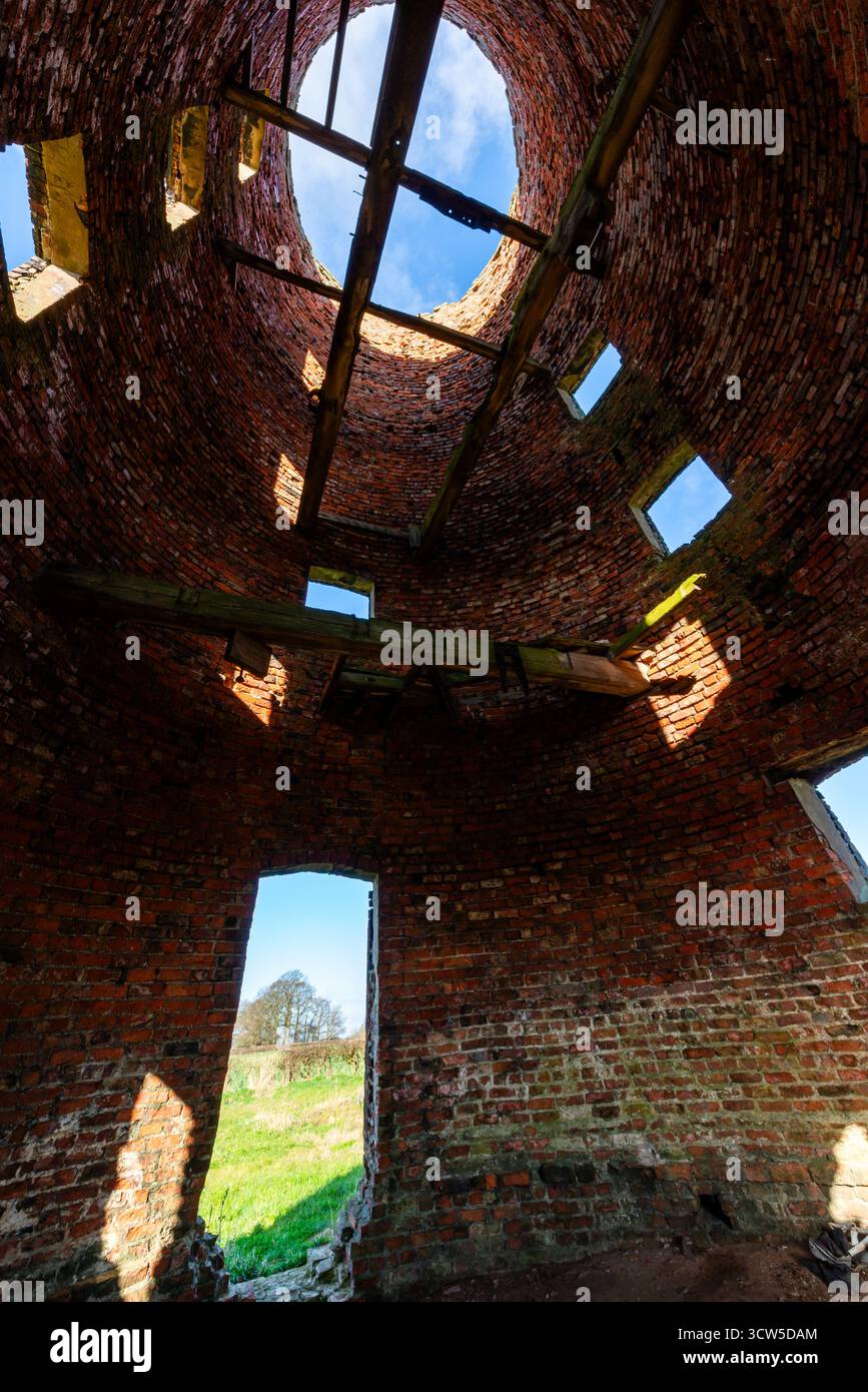 Interior of derelict brick windmill with open roof and wooden beams ...