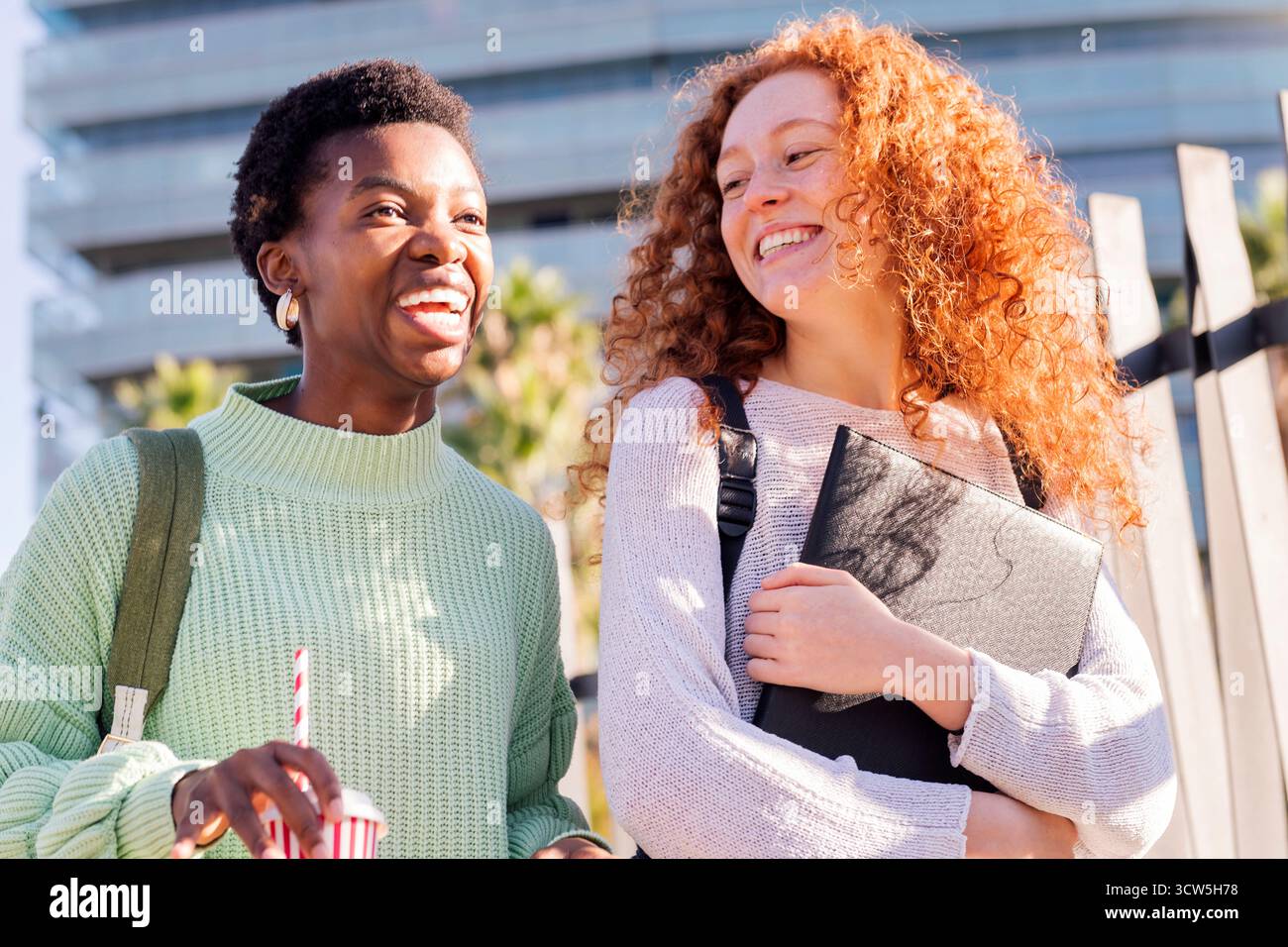 two young students walking down street Stock Photo