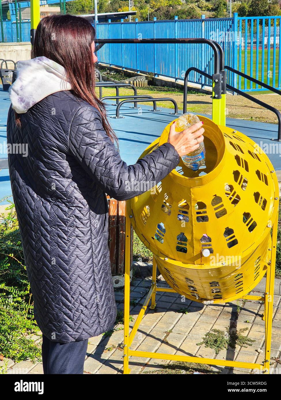 Disposal of garbage in a public park. woman recycling plastic bottle. - Smartphone Captured Stock Image