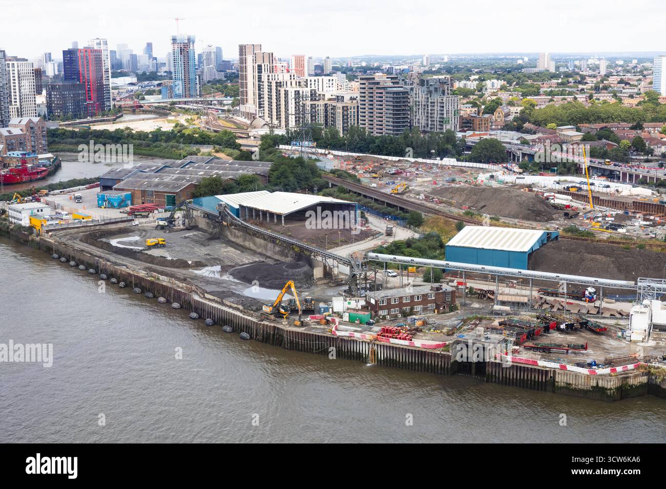 Aerial view of waterfront construction site with cranes and urban ...