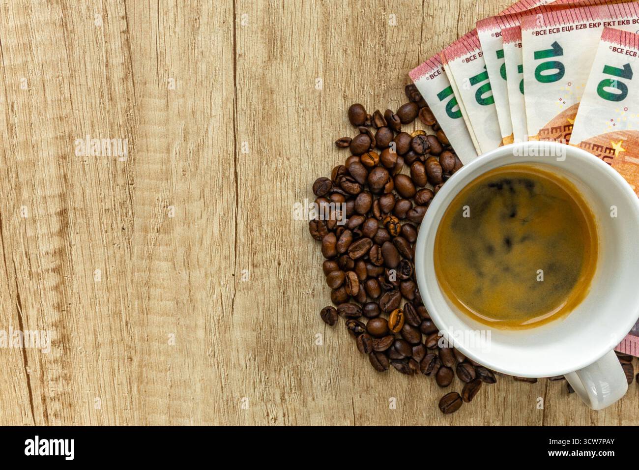 Top view of coffee beans, euro banknotes, and financial chart on wooden table. Symbol of rising coffee prices, inflation, and global market trends in Stock Photo