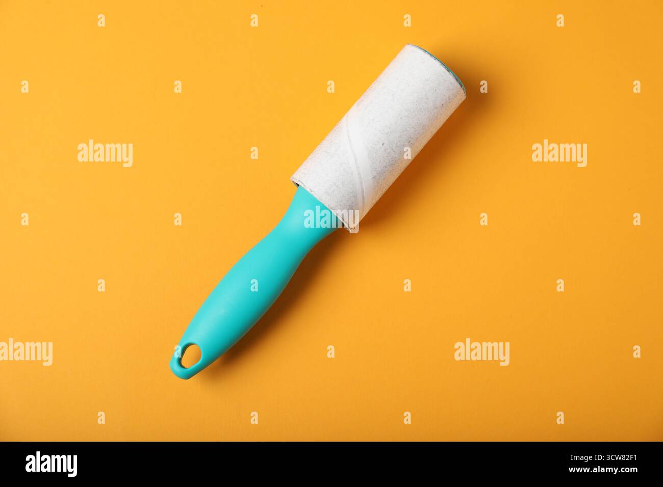 One lint roller on orange background, top view Stock Photo