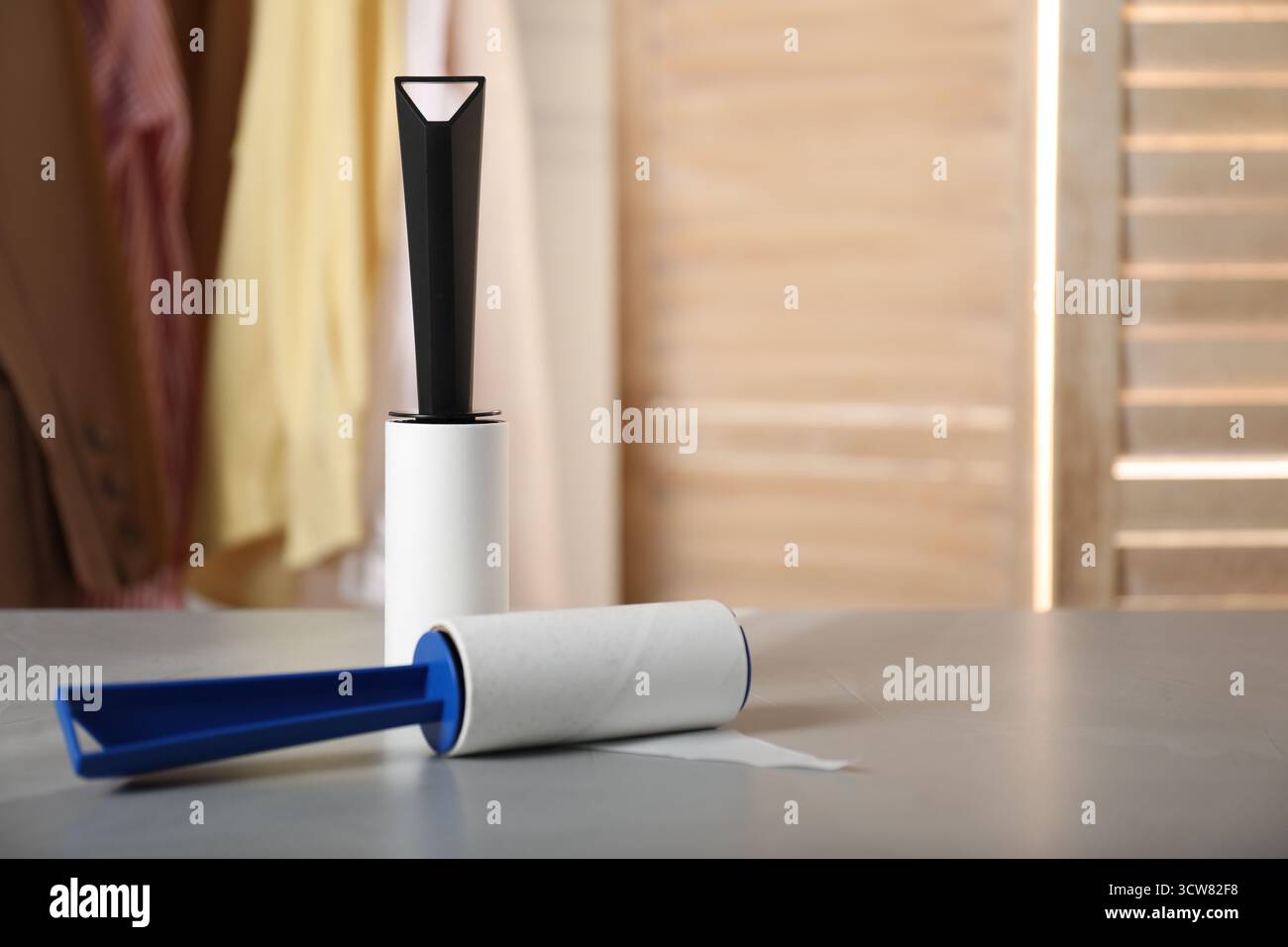 Lint rollers on grey table indoors, closeup. Space for text Stock Photo