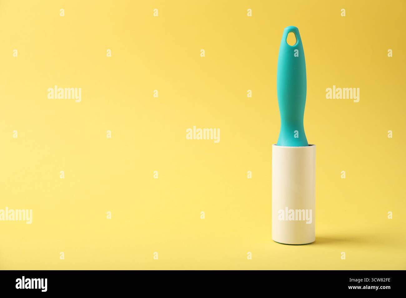 One lint roller on yellow background, space for text Stock Photo