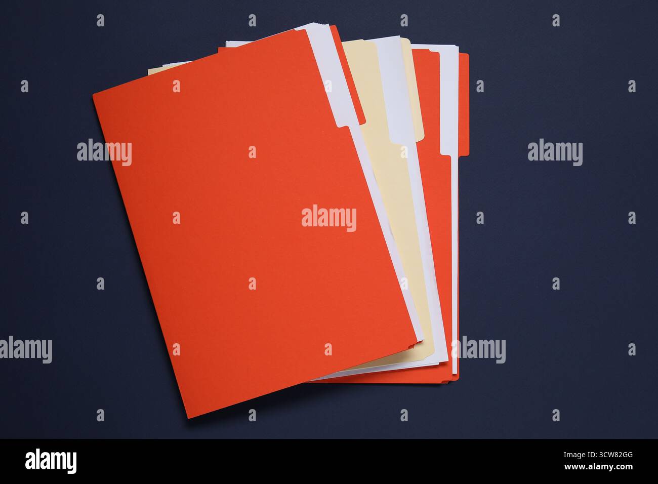 Many documents in folders on dark blue background, top view Stock Photo