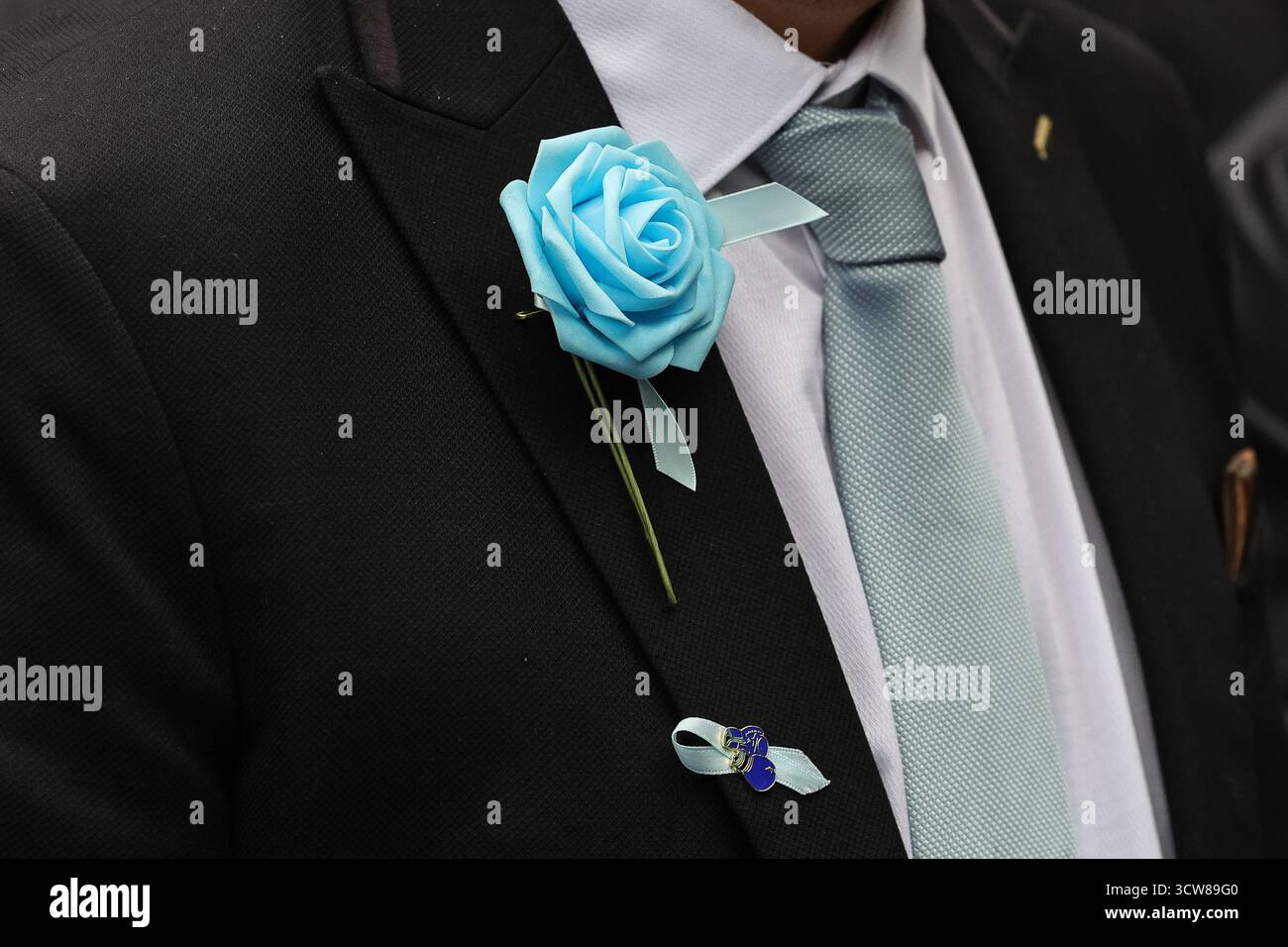 A mourner wearing a City blue rose and a boxing glove ribbon during ...