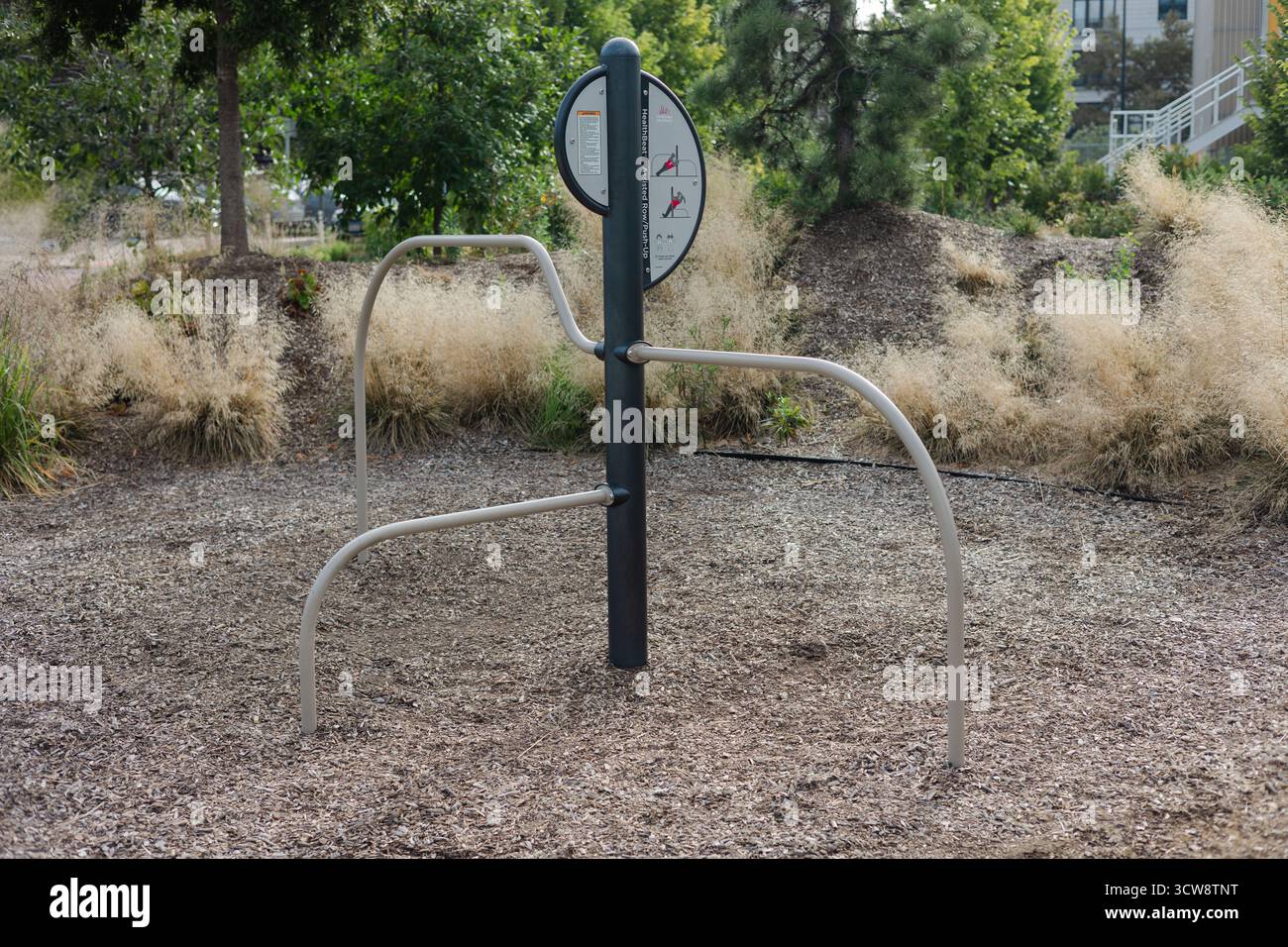 Outdoor fitness station stands in a park filled with trees and grass ...