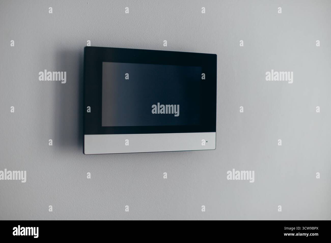 A video intercom screen on a white apartment wall Stock Photo