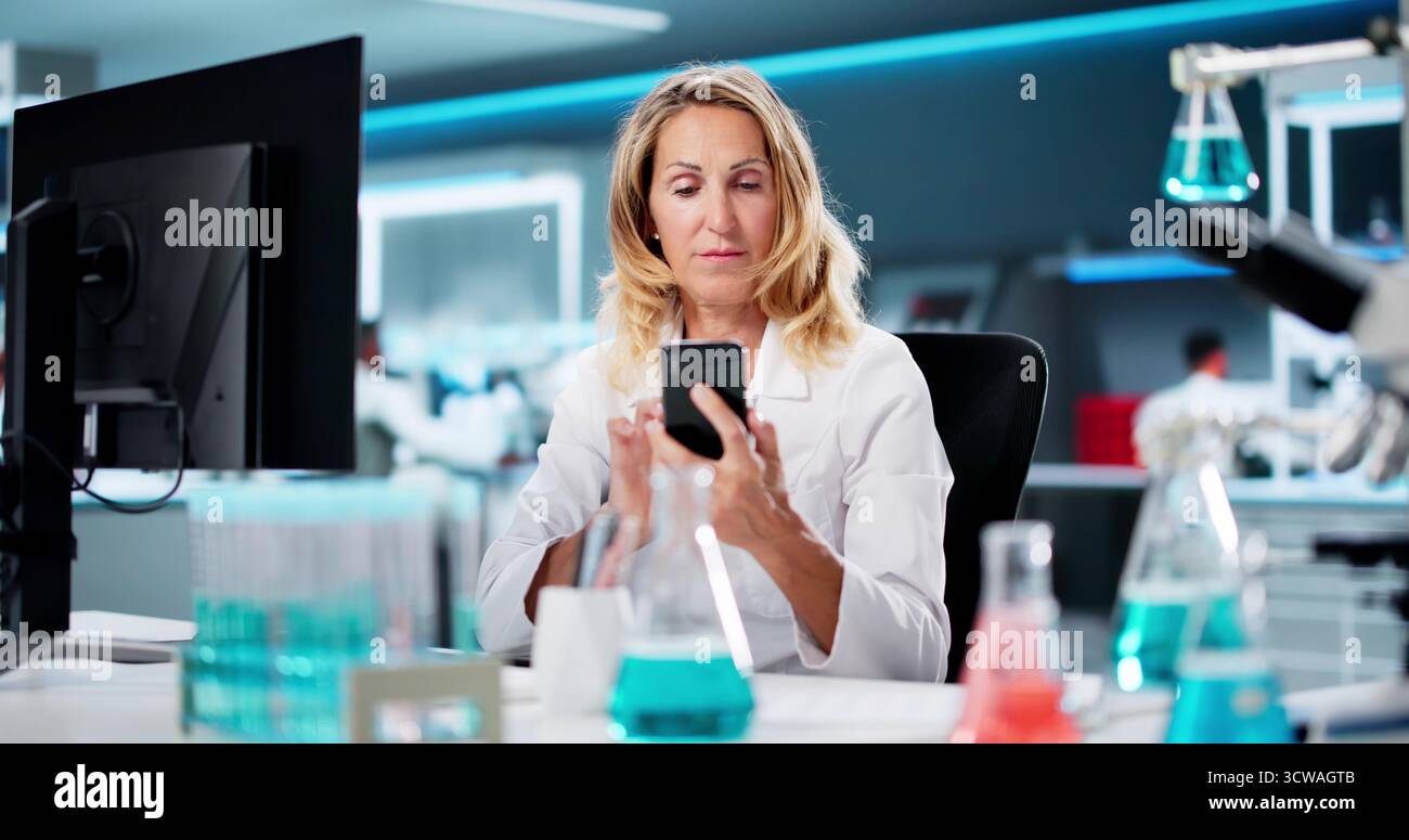 Woman Looking At Cell Phone, Texting, Viewing Document Stock Photo