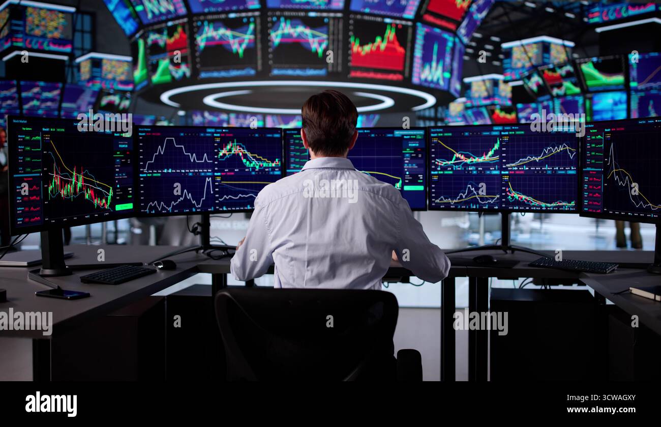 Senior Trader Analyzing Market Data On Computer At Stock Exchange. Stock Photo