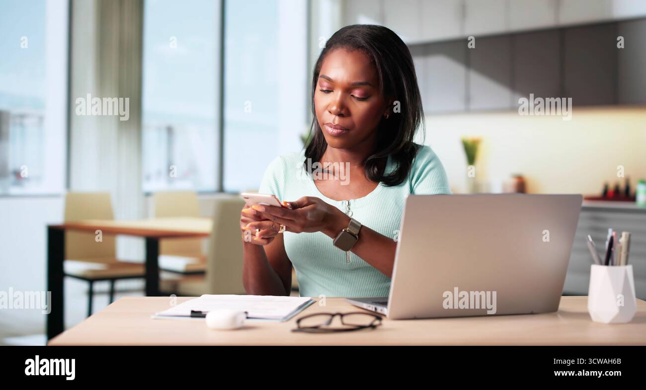 African Woman Scans Documents With Phone To Upload Receipt Online. Stock Photo