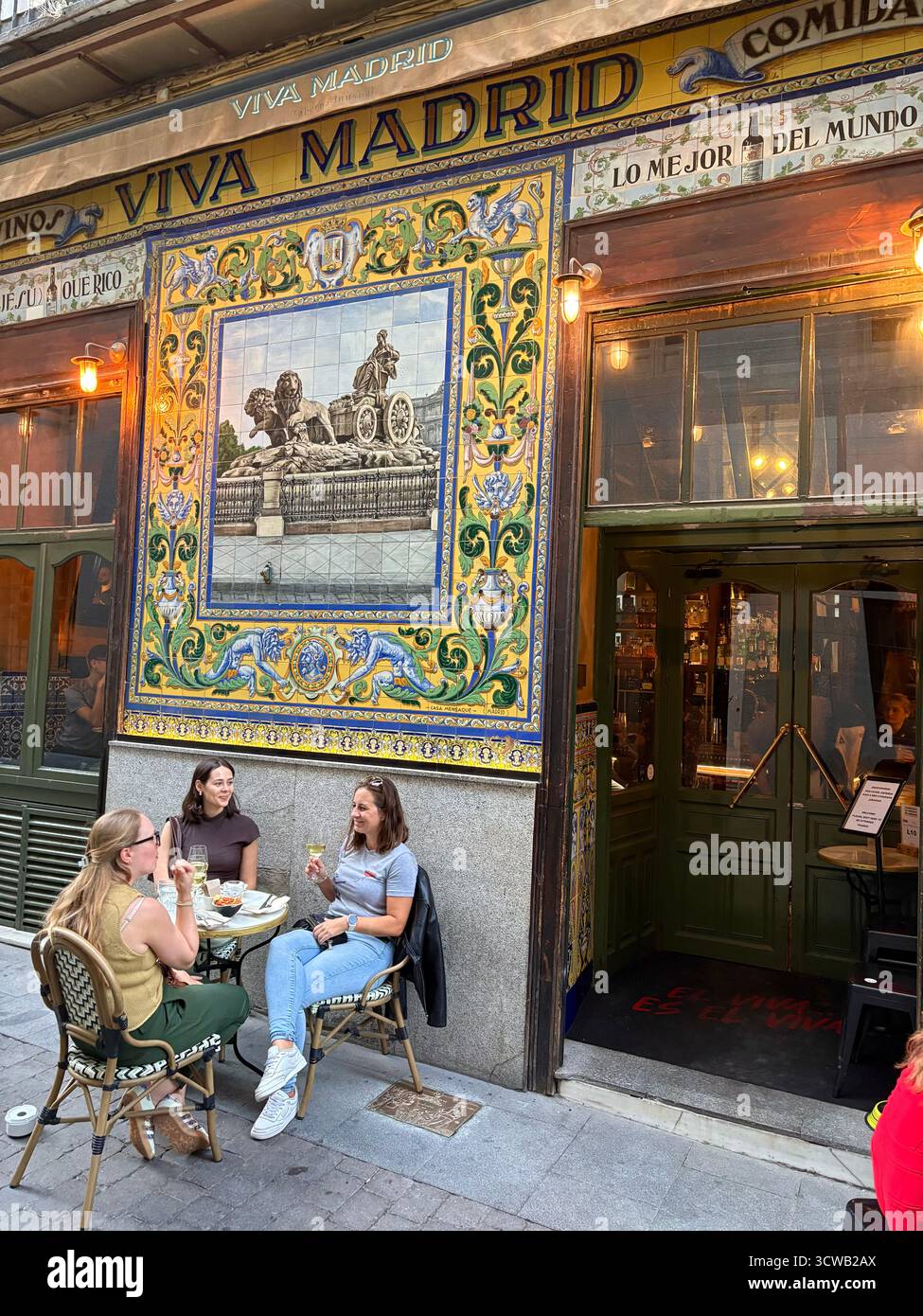 Viva Madrid tapas bar and restaurant with traditional wall tiles tiling on the facade, people friends drink and socialise outside, Spain,Europe - Smartphone Captured Stock Image