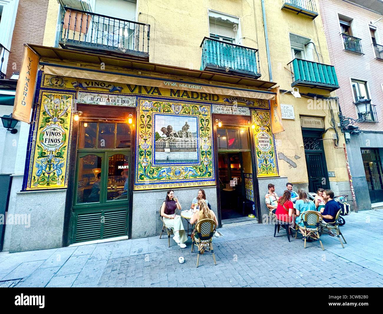 Viva Madrid tapas bar and restaurant with traditional wall tiles tiling on the facade, people friends drink and socialise outside, Spain,Europe - Smartphone Captured Stock Image