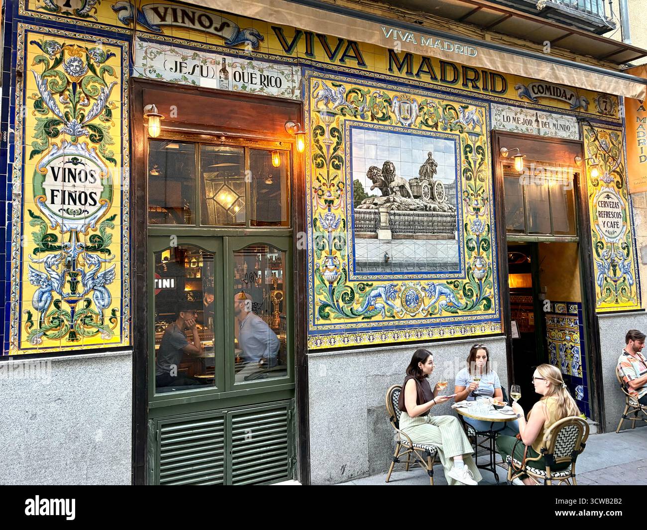 Viva Madrid tapas bar and restaurant with traditional wall tiles tiling on the facade, people friends drink and socialise outside, Spain,Europe - Smartphone Captured Stock Image