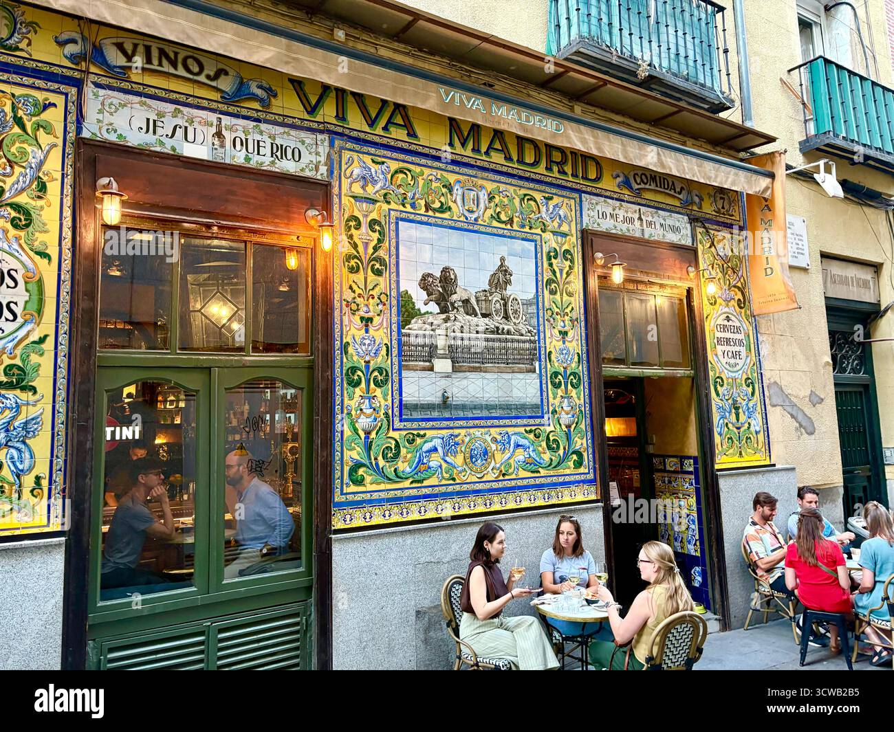 Viva Madrid tapas bar and restaurant with traditional wall tiles tiling on the facade, people friends drink and socialise outside, Spain,Europe - Smartphone Captured Stock Image