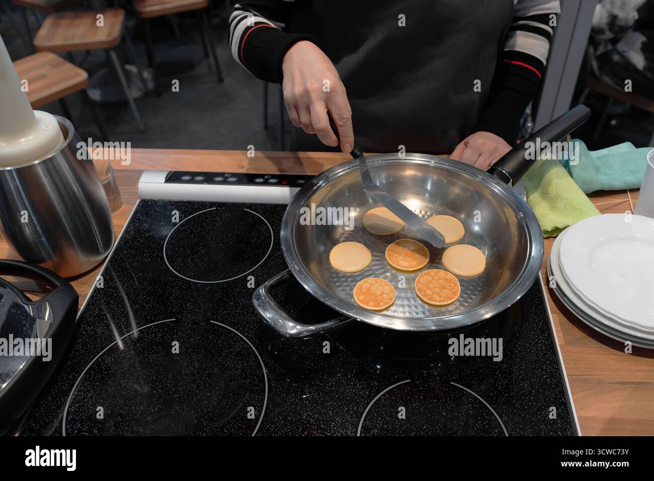 Frying mini pancake cereal in modern nonstick frying pan. Stock Photo