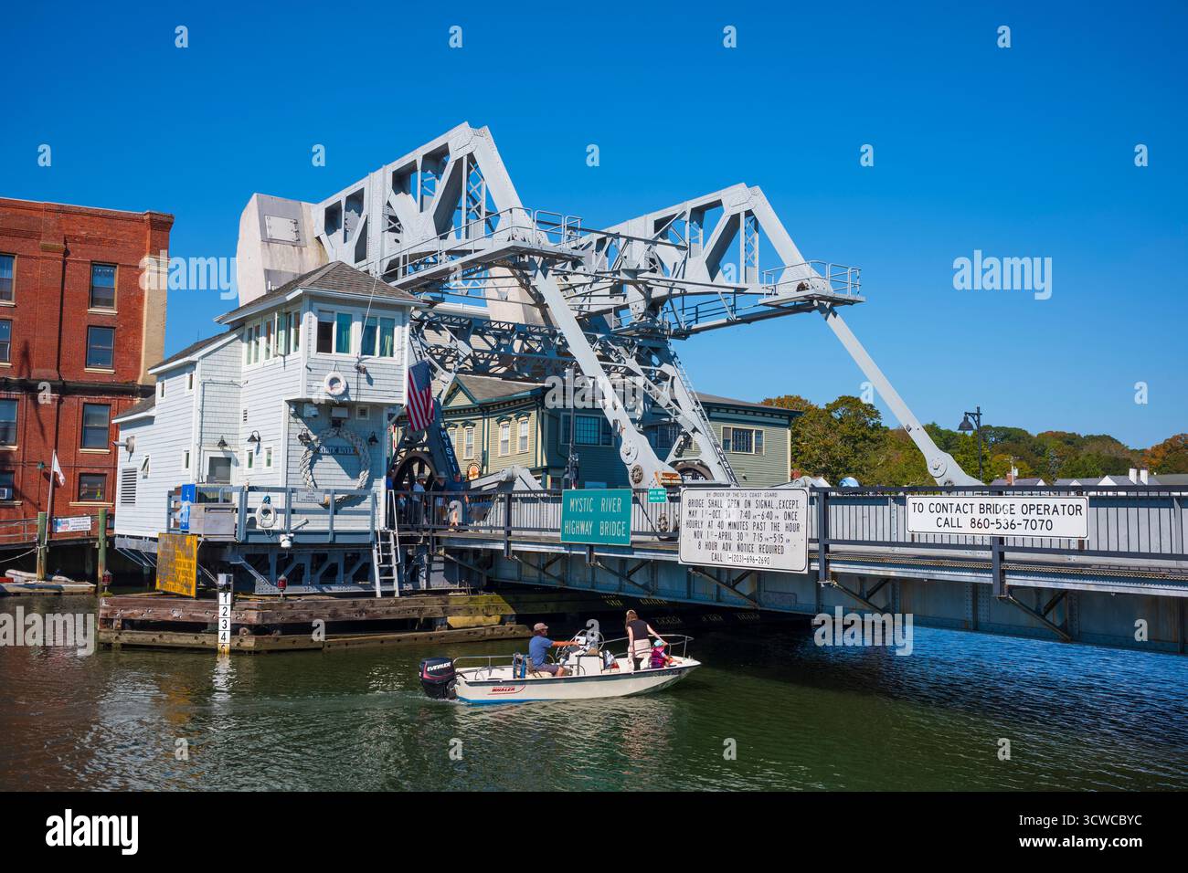 A small boat navigates the waters of the Mystic River, in Mystic, CT, in New England, seen from the Mystic River Bascule Bridge, during a beautiful fa Stock Photo