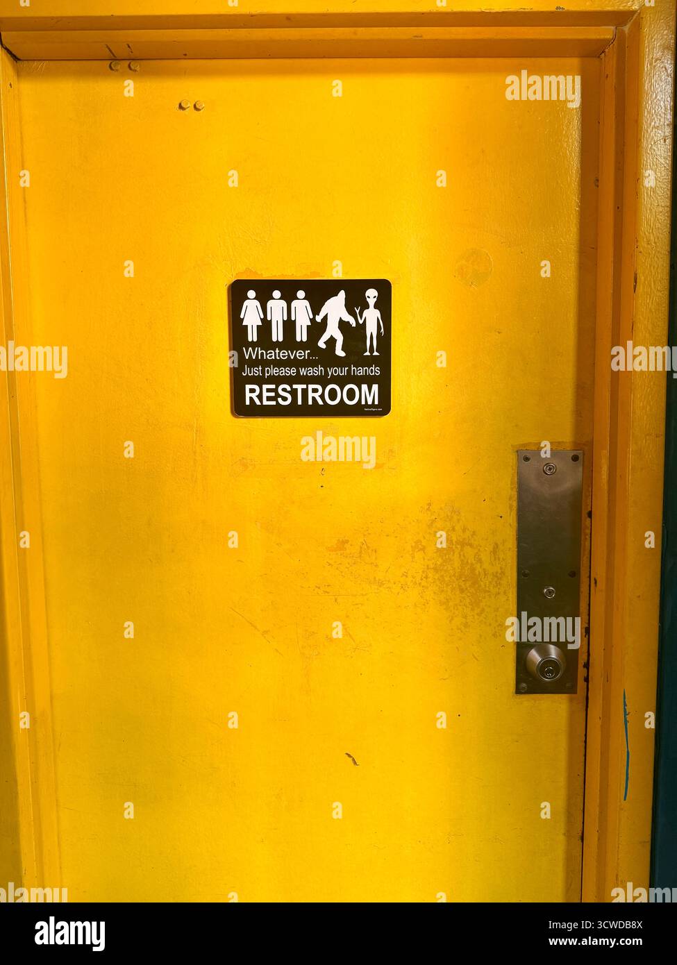 Unisex restroom door with humorous sign, New Orleans, USA - Smartphone Captured Stock Image