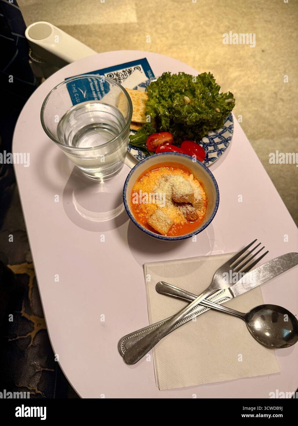 Light meal with soup, salad, and water served on a small table - Smartphone Captured Stock Image
