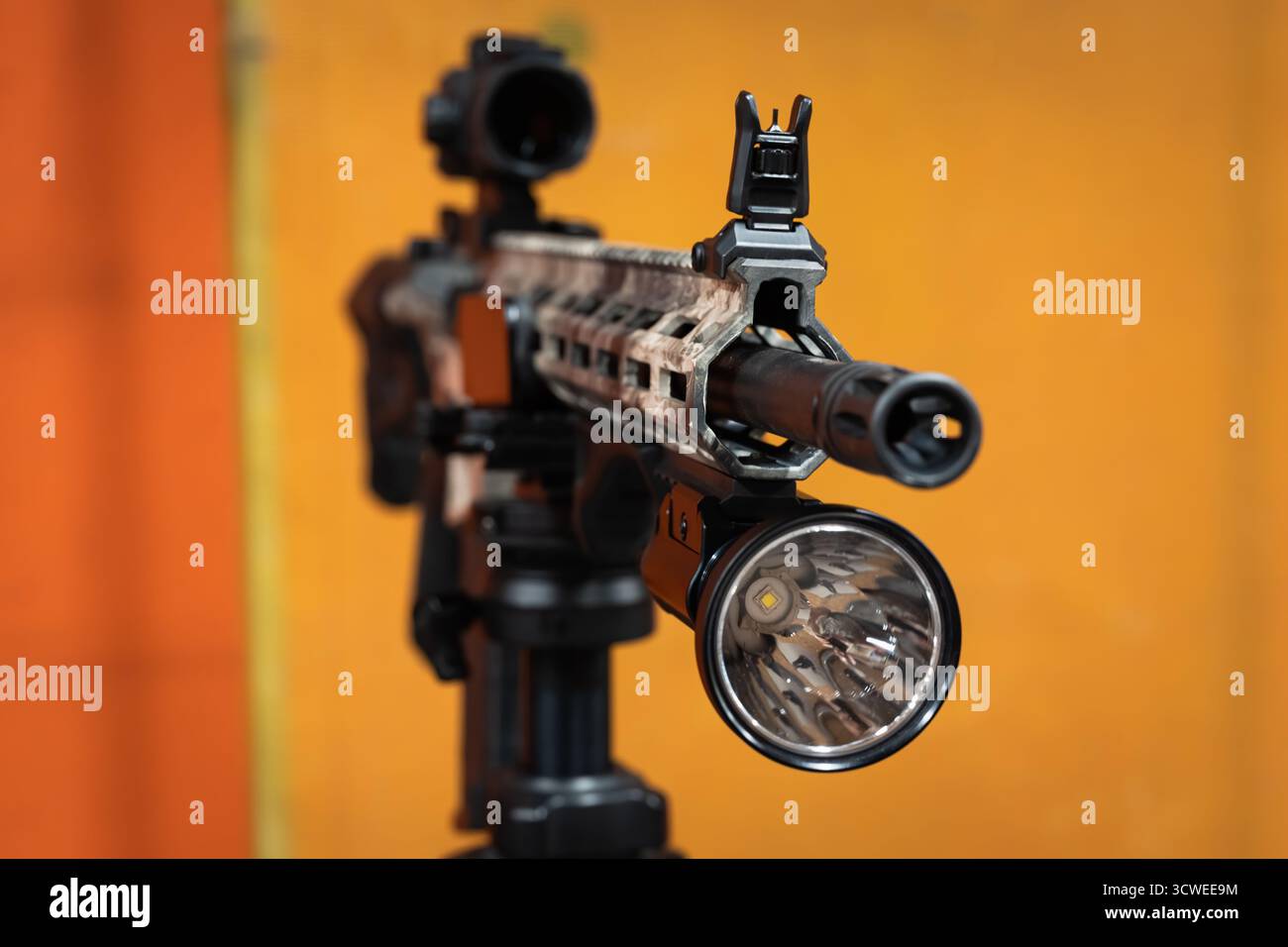 Close-up of a large, powerful tactical flashlight mounted on the rail ...